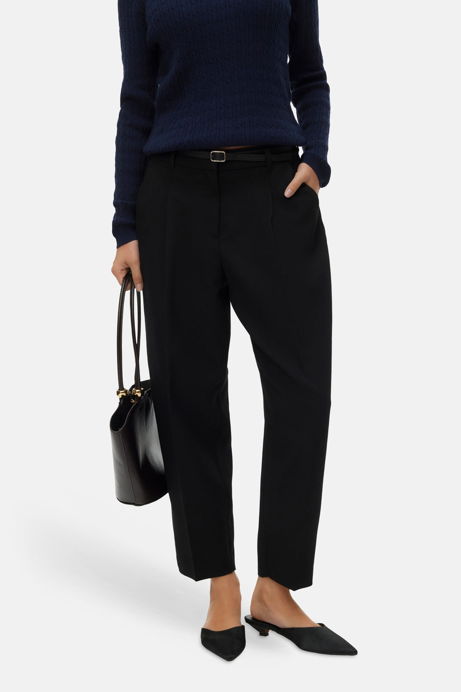 Pantalon noir de VERO MODA, avec une ceinture fine et un sac à main.