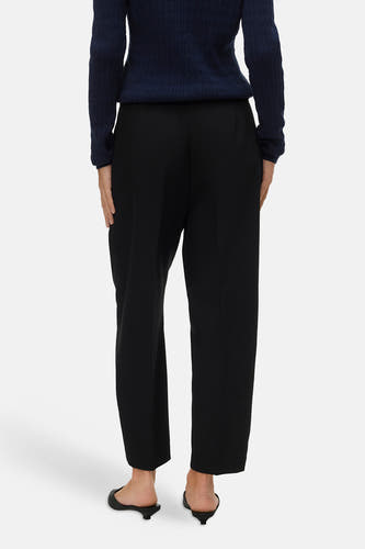 Pantalon noir de VERO MODA, vu de dos, avec un pull bleu foncé et des chaussures noires.