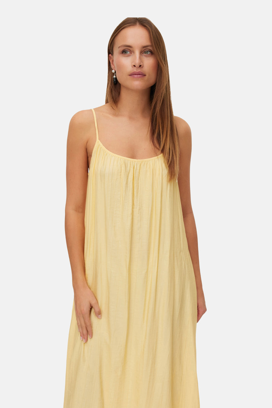 Robe sans manches de couleur jaune de Vero Moda, avec des bretelles spaghetti et de fins plis sur le dessus.