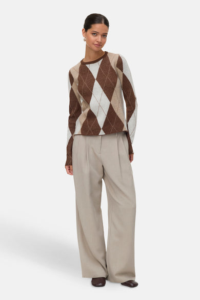 Pull marron avec col rond de VERO MODA®, en motif à carreaux, associé à un pantalon beige et des chaussures marron foncé.