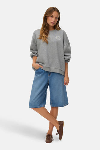 Korte midblauw denim broek van VERO MODA, met wijde pijpen en bruine schoenen.
