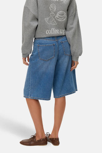 Mid blue denim short van VERO MODA, met achterzakken, gecombineerd met een grijze sweater met koffie print.