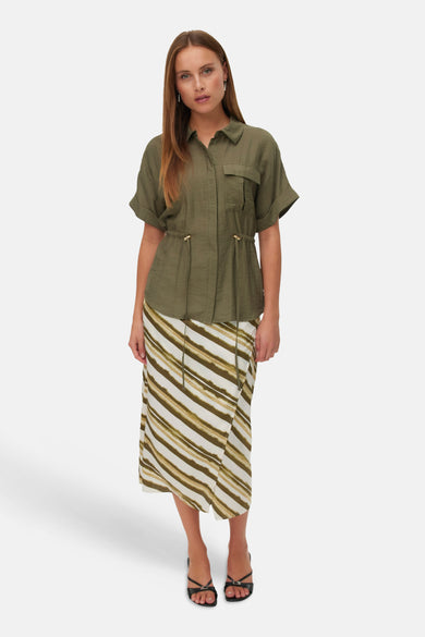 Chemisier vert de VERO MODA, à manches courtes, poche poitrine et une jupe rayée.