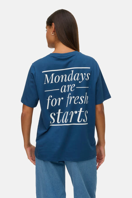 T-shirt bleu à manches courtes de VERO MODA® avec "start now" imprimé en petit, associé à des jeans larges et des baskets.