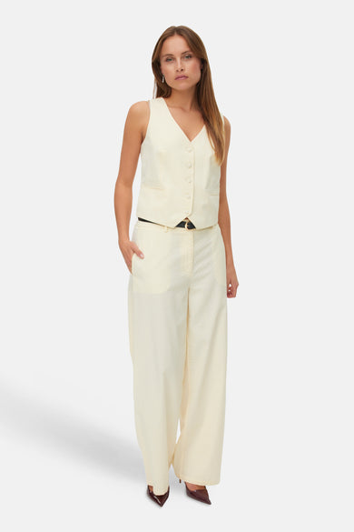 Gilet jaune de VERO MODA, dos avec fines rayures combiné avec un pantalon assorti.
