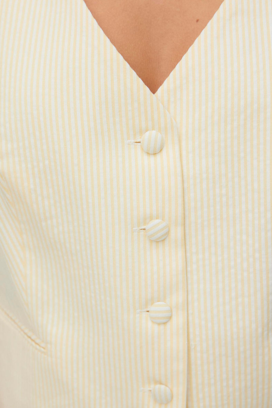 Gilet jaune à rayures de VERO MODA®, avec une fermeture à boutons sur le devant.