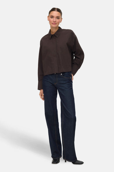 Chemise brune à manches longues de VERO MODA, portée avec un short en denim foncé et des chaussures noires.