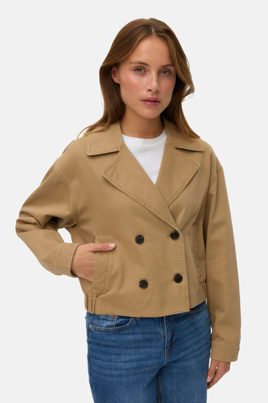 Veste courte marron de Vero Moda avec double boutonnage, portée avec un t-shirt blanc et un jean ample.
