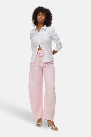 Roze gekleurde jeans van VERO MODA, met wijde pijpen en een decoratieve bloem op de tailleband.
