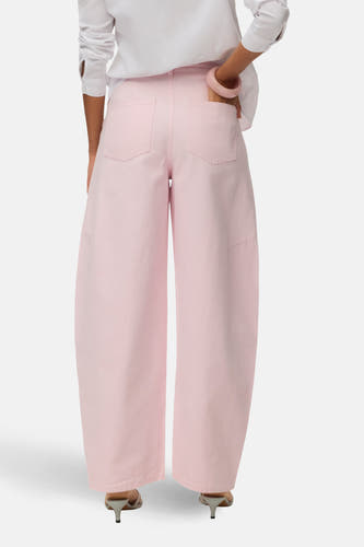 Roze gekleurde jeans van VERO MODA, met wijde pijpen en achterzakken, gecombineerd met een witte blouse en hakken.