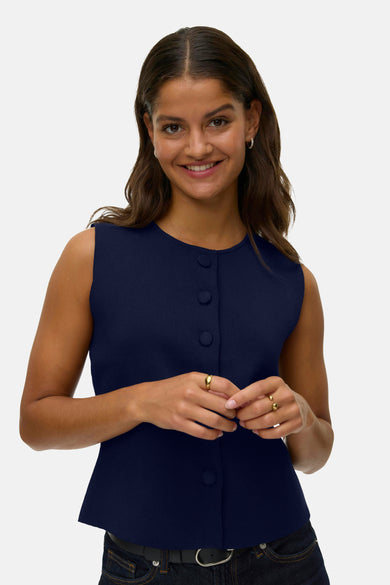 Blauw gilet van VERO MODA, met knoopsluiting, gedragen met een jeans en riem.
