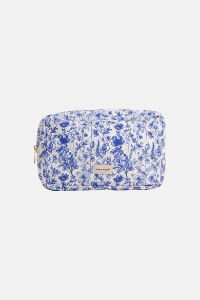 Trousse de toilette bleue de Vero Moda, avec motif floral et fermeture éclair dorée.