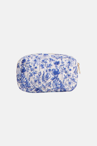 Trousse de toilette bleue VERO MODA® avec un imprimé à fleurs blanches et une fermeture éclair dorée.