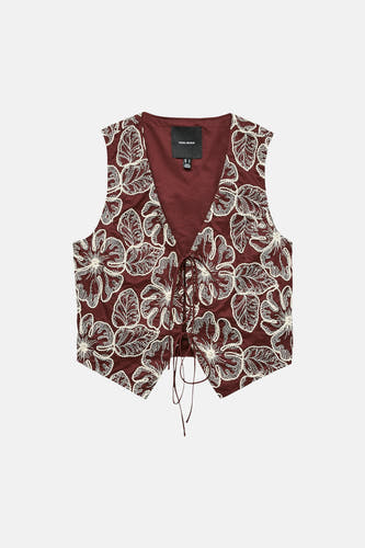 Gilet marron de VERO MODA avec broderie florale blanche et fermeture à nouer sur le devant.