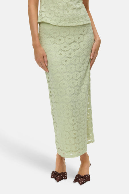 Jupe longue verte de VERO MODA, avec dentelle florale, vue de dos, portée avec des talons marron à pois.