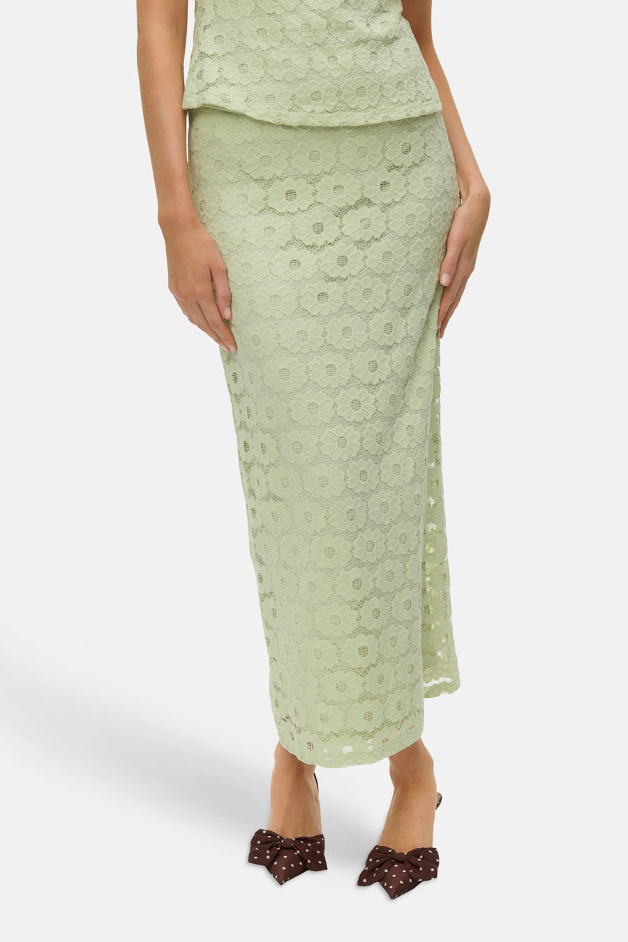 Jupe longue verte de VERO MODA, avec dentelle florale, vue de dos, portée avec des talons marron à pois.