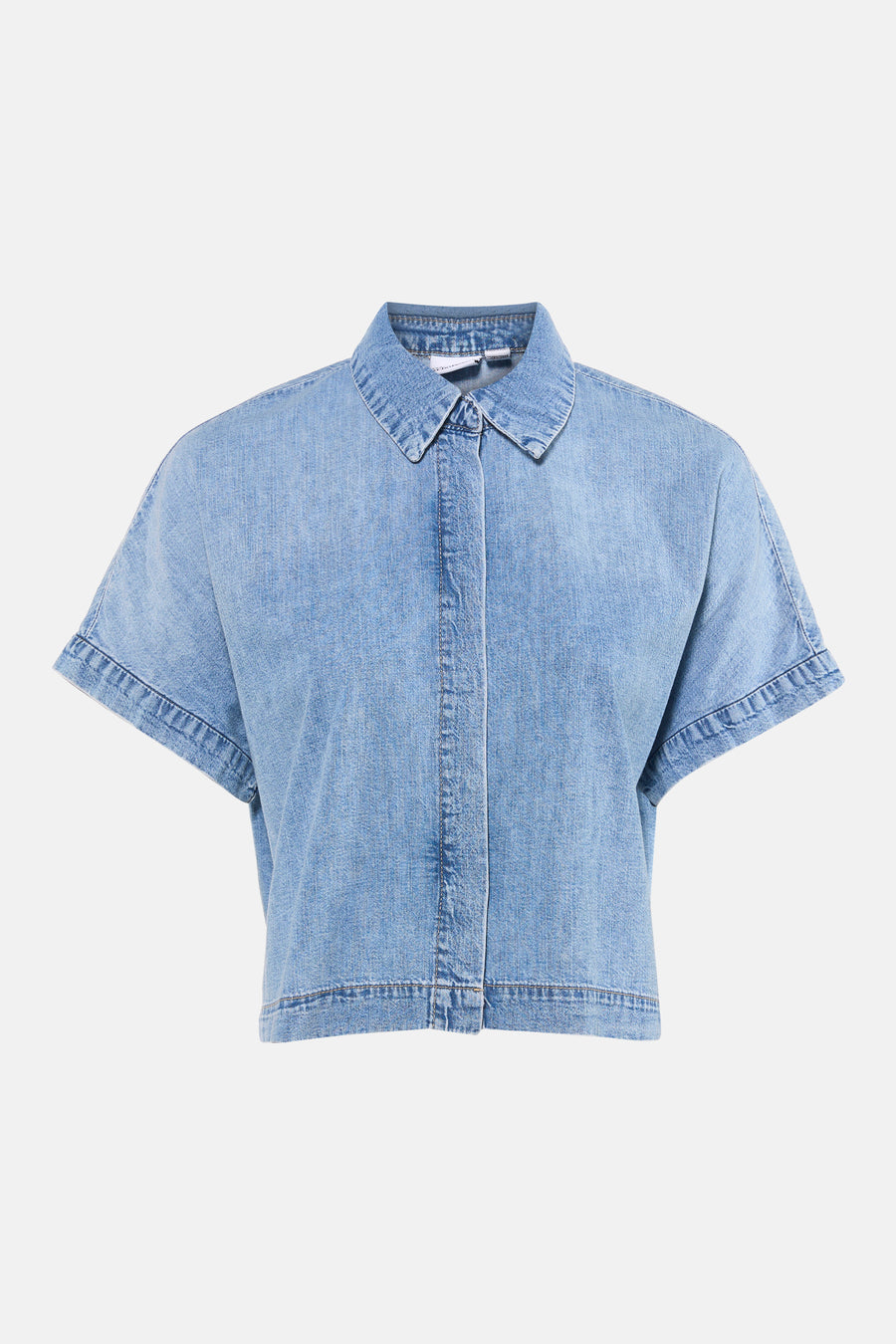 Chemisier en denim bleu clair à manches courtes de VERO MODA®, avec col et fermeture boutonnée dissimulée sur le devant.