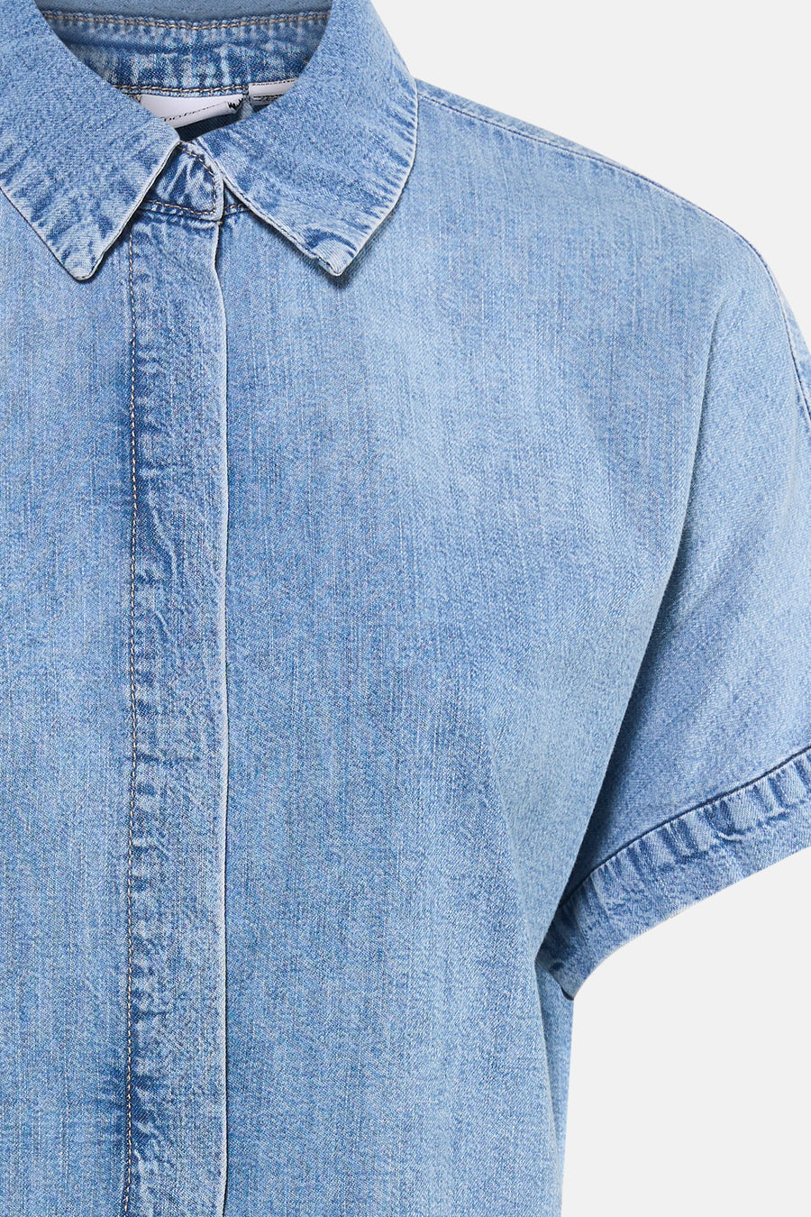 Chemisier en jean bleu clair à manches courtes de VERO MODA®, avec col visible, patte de boutonnage et coutures.