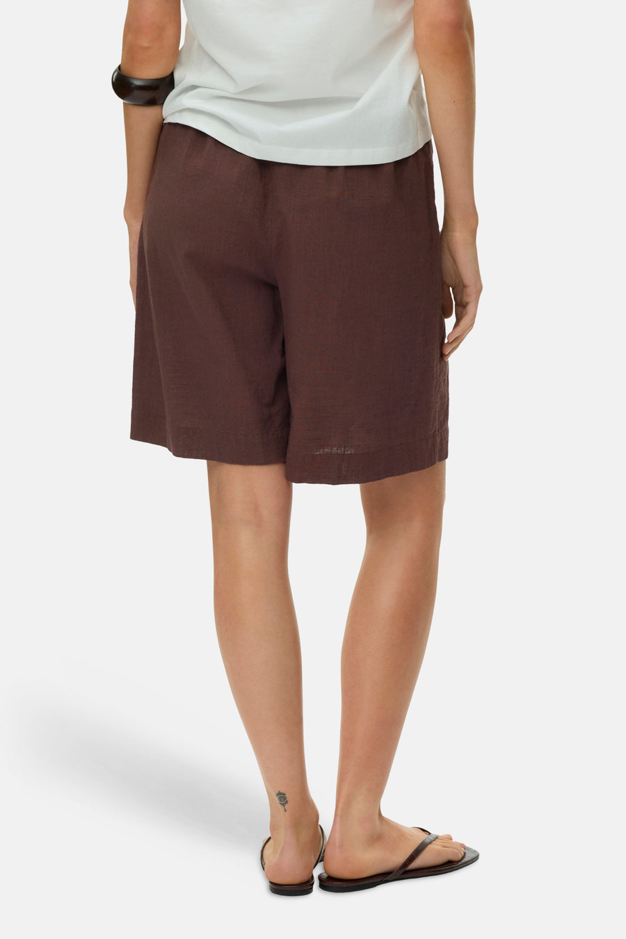 Bruine korte broek van VERO MODA®, linnenlook, comfortabele pasvorm, achterzijde, model draagt wit topje en sandalen