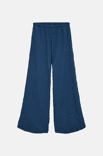 Blauwe broek van VERO MODA met een gekreukte textuur en wijde pijpen.