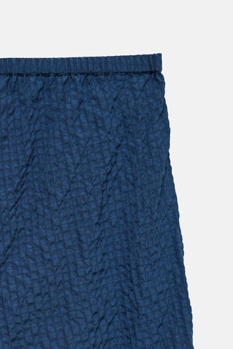 Blauwe broek van VERO MODA, met een geweven textuur en elastische tailleband, close-up.
