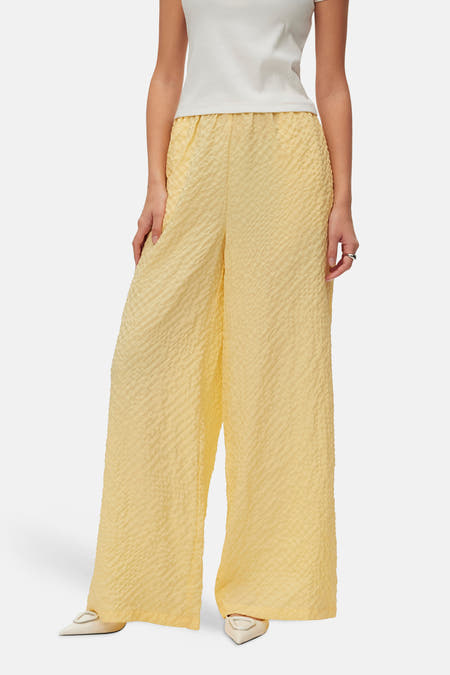 Gele broek van VERO MODA® met een geplooide textuur en een wijde pijp.