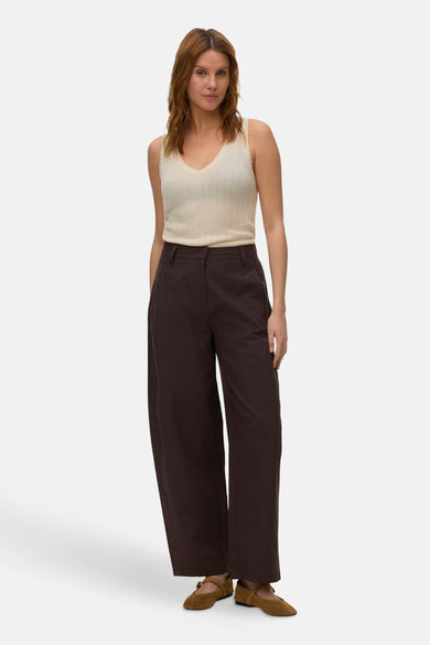 Pantalon marron de VERO MODA, avec poches arrière et jambes amples, porté avec des chaussures marron.