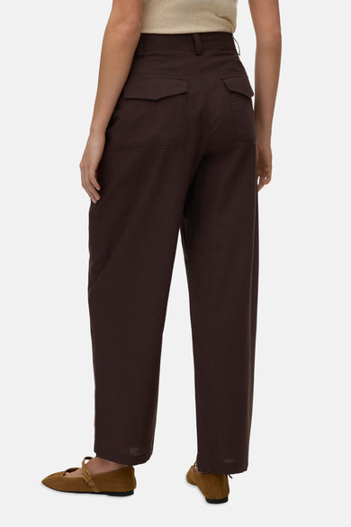 Bruine broek van VERO MODA, met achterzakken en losse pijpen, gedragen met bruine schoenen.
