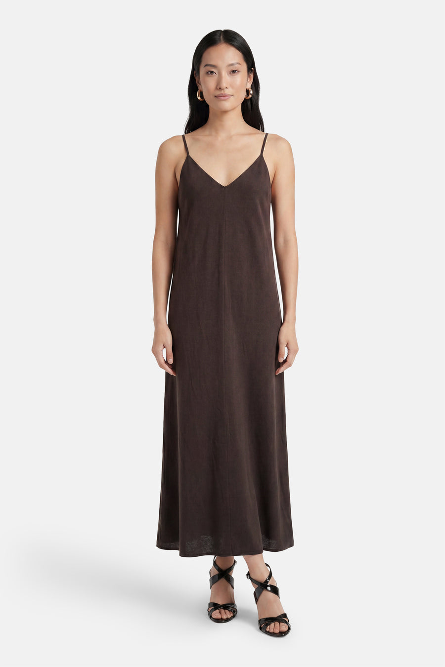 Bruin mouwloos kleedje van VERO MODA® met V-hals en spaghettibandjes, gedragen met zwarte sandalen.