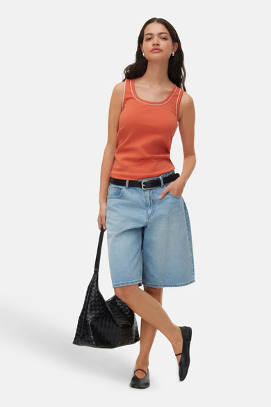 Oranje mouwloze top met witte rand van VERO MODA®, gedragen met jeansshorts en zwarte tas, lifestyle shot