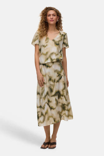 Multicolor korte mouwen blouse van VERO MODA® met abstract groen en beige patroon, V-hals en elastische taille, gedragen met een bijpassende midi-rok en bruine sandalen.