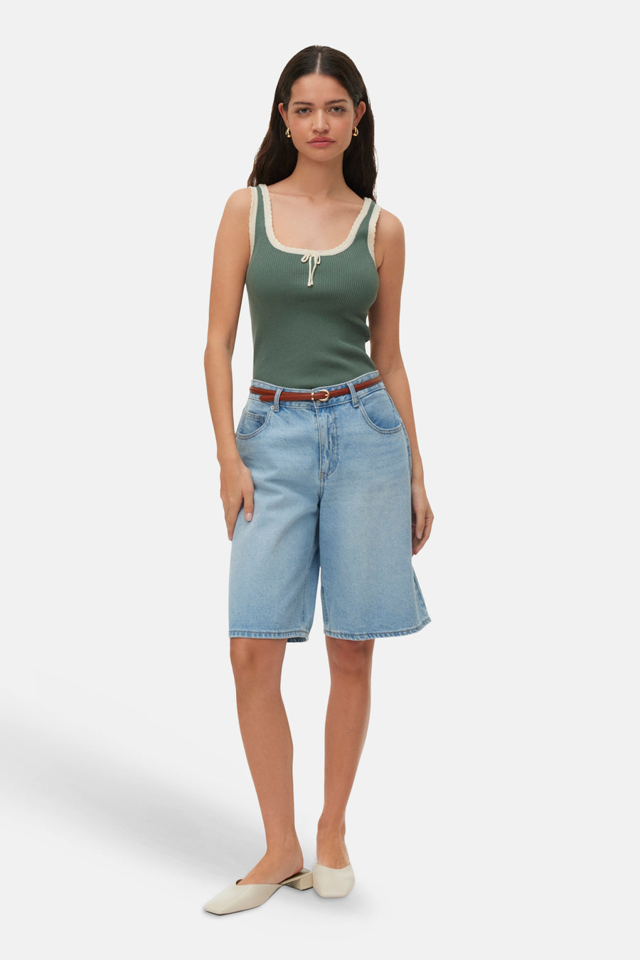 Groene geribbelde top van VERO MODA® met roomwitte boorden en strikdetail, gedragen met denim shorts en beige muiltjes.