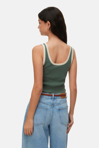 Groene geribbelde top van VERO MODA® met geschulpte beige rand, gedragen door vrouw, rugaanzicht, met spijkerbroek.