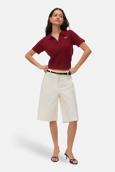 Ecru bermuda van VERO MODA® met hoge taille, gecombineerd met een rood poloshirt en hakken.