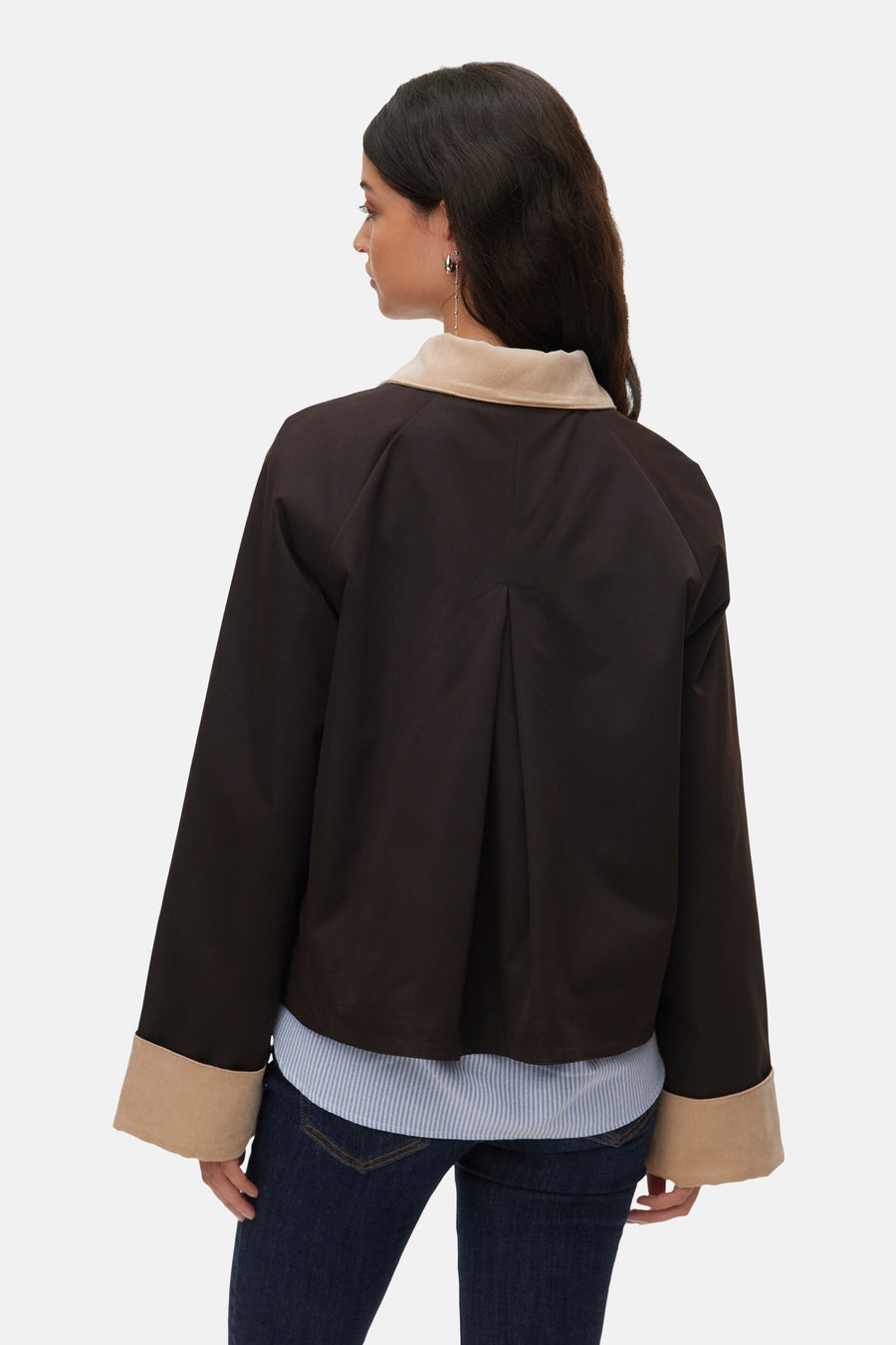 Bruine korte jas van VERO MODA, gezien van achteren, met beige kraag en manchetten, gedragen over een gestreept overhemd en jeans.