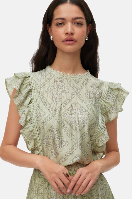 Chemisier vert à manches courtes de VERO MODA, avec motif détaillé, volants et bordures en dentelle, vue de côté.