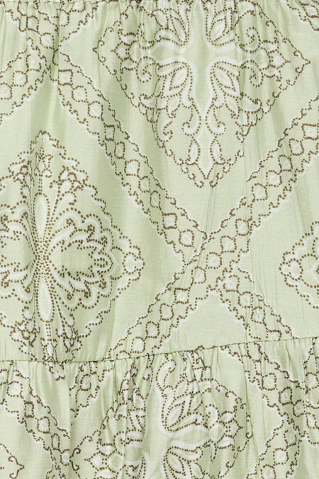 Lichtgroene rok van VERO MODA® met bruin stippenpatroon van geometrische en paisley-achtige vormen, en een geplooide onderrand.