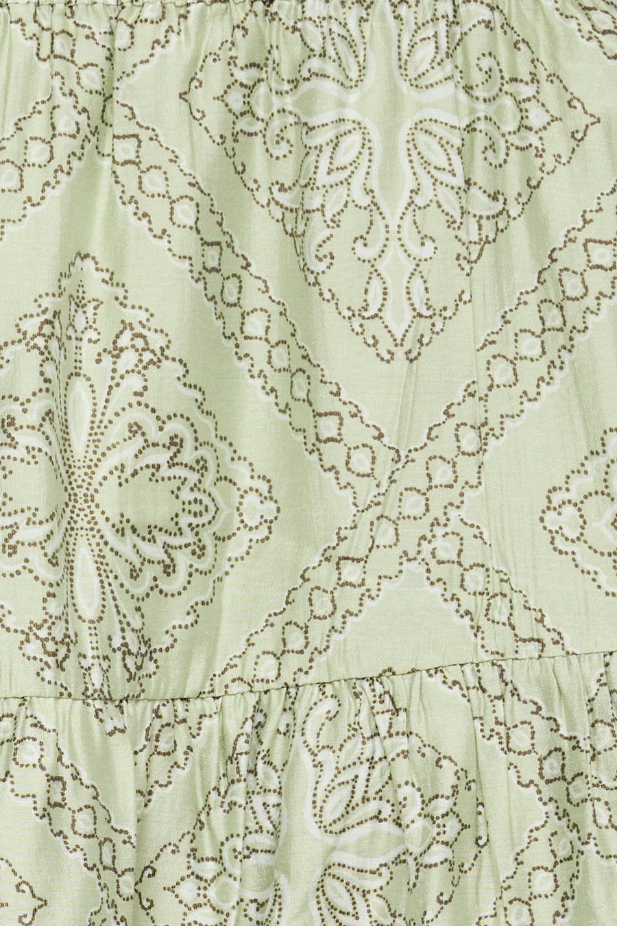 Lichtgroene rok van VERO MODA® met bruin stippenpatroon van geometrische en paisley-achtige vormen, en een geplooide onderrand.