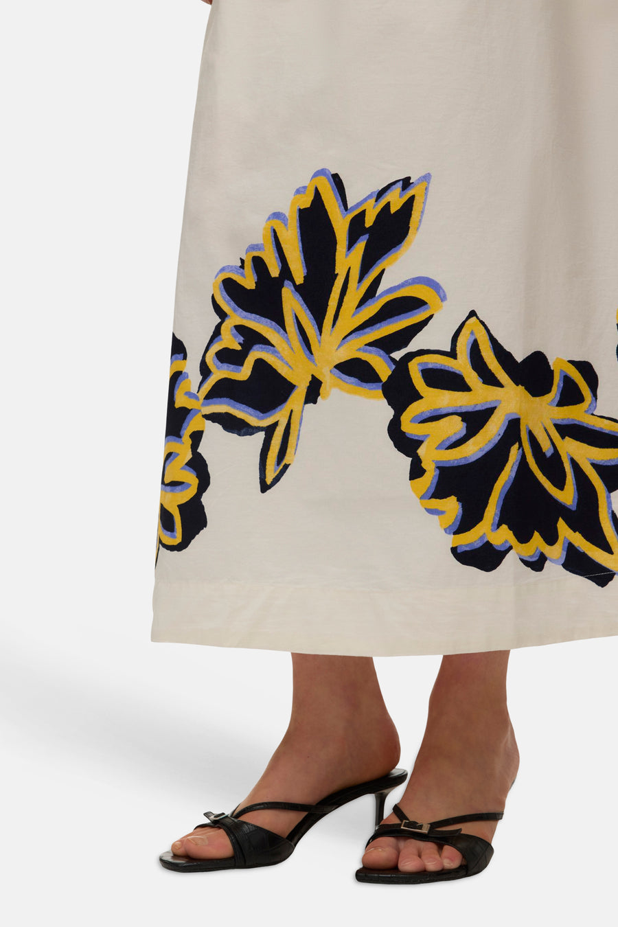 Jupe longue écru de VERO MODA avec motif floral abstrait en noir, jaune et lilas, portée avec des sandales noires à talons.