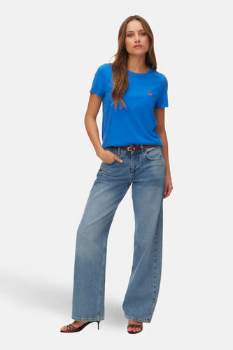 Blauw T-shirt met korte mouwen van VERO MODA®, met een kleine watermeloenprint, gecombineerd met wijde jeans en hakken.
