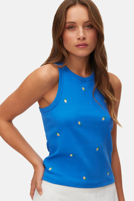 Débardeur bleu de VERO MODA, avec une texture côtelée, combiné avec une jupe blanche.