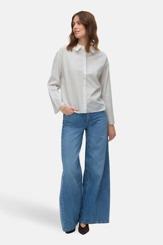 Wit overhemd met lange mouwen van VERO MODA®, met verticale strepen, gecombineerd met wijde jeans en bruine schoenen.