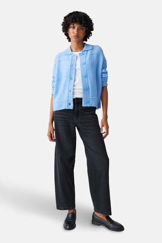 Blauwe trui van OPUS, gedragen met een wit shirt en zwarte jeans met wijde pijpen.