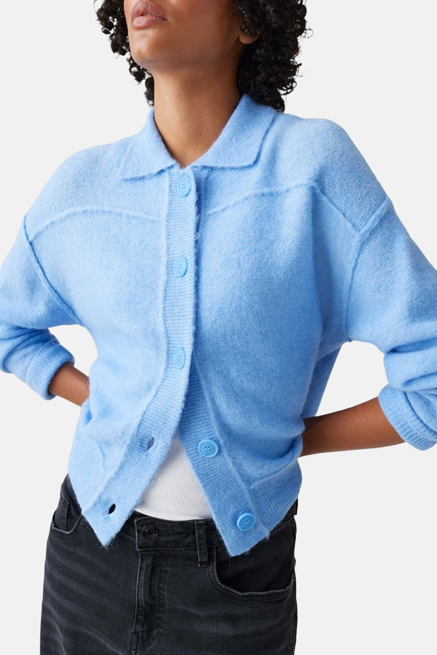 T-shirt bleu OPUSUS avec boutoup et et et man long, porté avec un jeans noir.