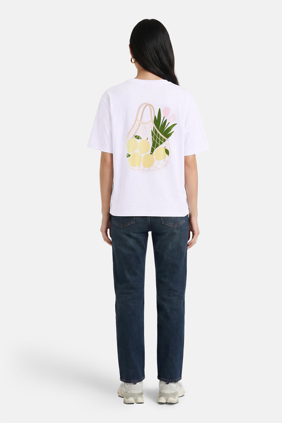 Witte korte mouwen T-shirt van VERO MODA® met fruitmand print op rug, gedragen met donkerblauwe jeans en witte sneakers, achterkant weergegeven