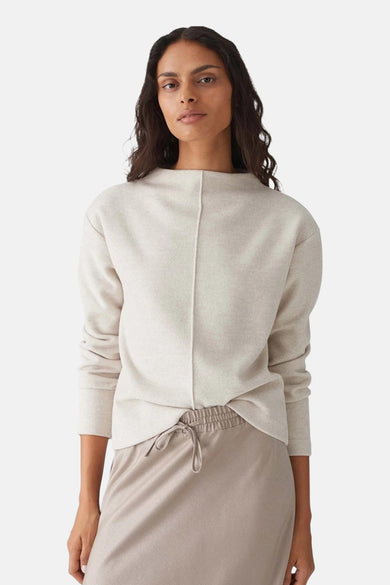 Blouse écru avec col rond d'OPUS, dos avec une couture sur le milieu, associée à une jupe beige.