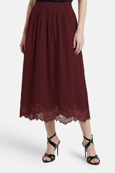 Bordeauxrode rok van VERO MODA® met geplooide taille en kanten zoom, gedragen met zwarte hakken.