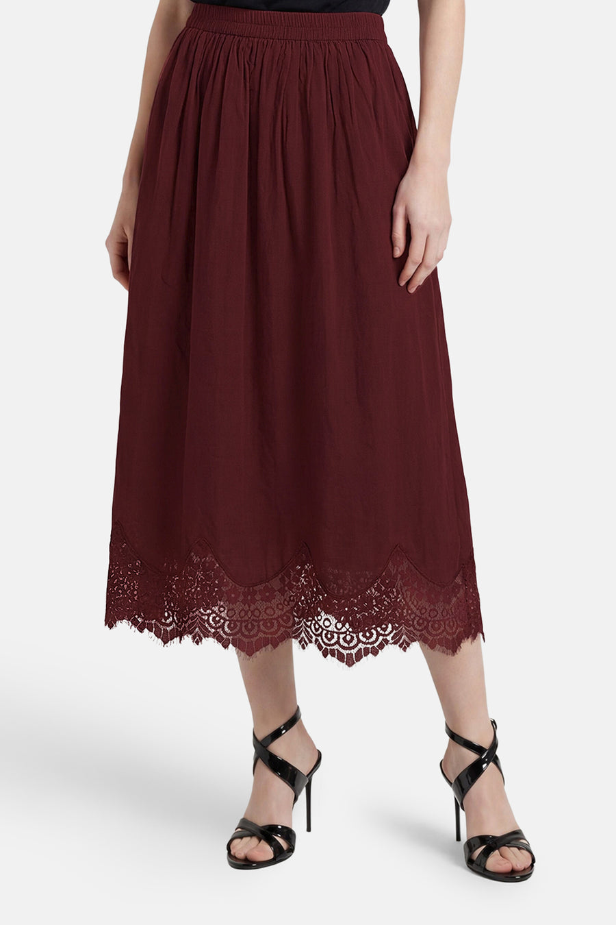Bordeauxrode rok van VERO MODA® met geplooide taille en kanten zoom, gedragen met zwarte hakken.
