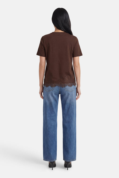 Bruin T-shirt met korte mouwen van VERO MODA® met kanten boord aan de zoom, gedragen met blauwe jeans, achterzicht.