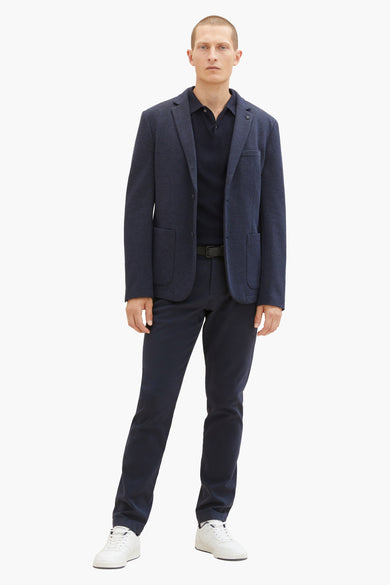 Jean bleu de TOM TAILOR, porté avec un poloshirt bleu marine, une veste et des baskets blanches.